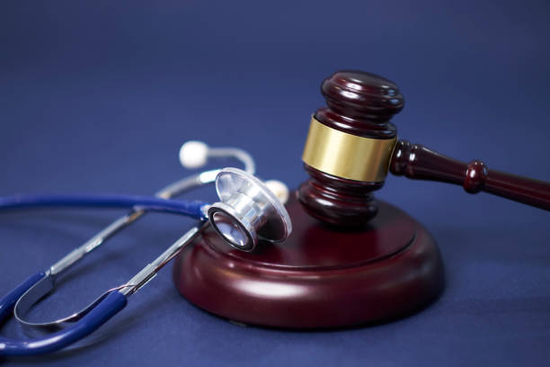 A stethoscope sits on a wooden platform next to a gavel